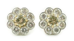 A pair of gold and nine stone diamond cluster set flower head ear studs, each central stone of a