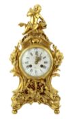 A Louis XVI style ormolu mantel clock, with Cupid and dolphin finial over an enamelled Roman dial,