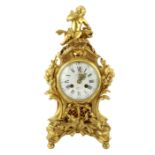 A Louis XVI style ormolu mantel clock, with Cupid and dolphin finial over an enamelled Roman dial,