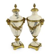 A pair of Italian ormolu mounted calacaita marble urns, with fruiting finials and ram's head and