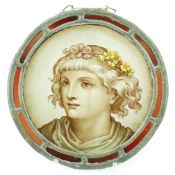 A Victorian stained glass roundel, depicting a Pre-Raphaelite youth with flowers in his hair, within