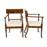 A pair of Edwardian Sheraton revival painted satinwood elbow chairs, decorated with cherubs, flowers