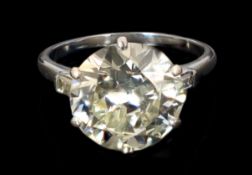 A platinum and single stone diamond set ring, with baguette cut diamond set shoulders, the round cut