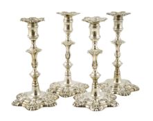 A set of four George II cast silver table candlesticks, by John Cafe, with knopped baluster stems