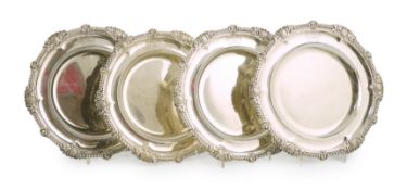 A set of four George IV silver dinner plates by Rundell, Bridge & Rundell, with gadrooned, shell and