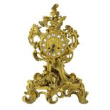 A 19th century French ormolu mantel clock, of asymmetrical scroll form, with enamelled tablet