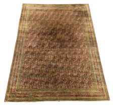 A Khorasan red ground carpet, woven with rows of boteh, approximately 12ft. X 9ft. (damage to one