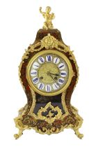 An early 20th century French ormolu mounted red boulle work mantel clock, with putto finial and