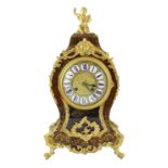 An early 20th century French ormolu mounted red boulle work mantel clock, with putto finial and
