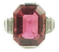 An Art Deco platinum and single stone emerald cut deep pink tourmaline set dress ring, with