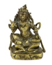 * A Tibetan gilt bronze figure of a deity, 17th century, holding a purba in his right hand, seated