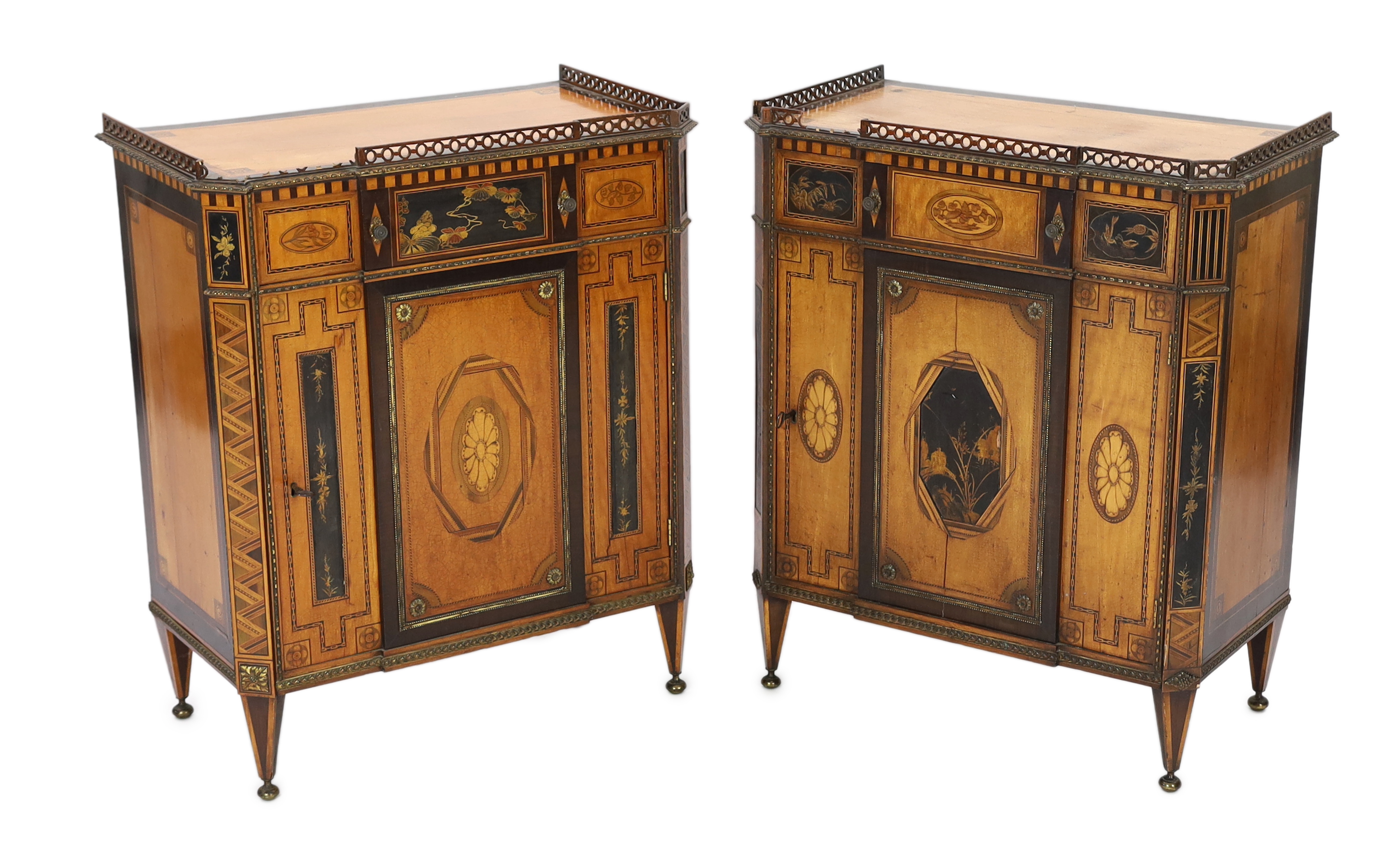 A pair of French Transitional style satinwood and marquetry side cabinets, each with fretwork