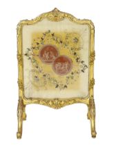 * A Louis XV style carved giltwood framed fire screen, the silk panel printed with roundels of