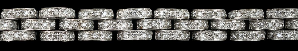 An 18k white gold and diamond chip set triple row bracelet, with demi-lune links, 20.4cm, gross