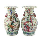 A pair of Chinese enamelled porcelain 'dragon and Buddhist lion' vases, 19th century, each painted