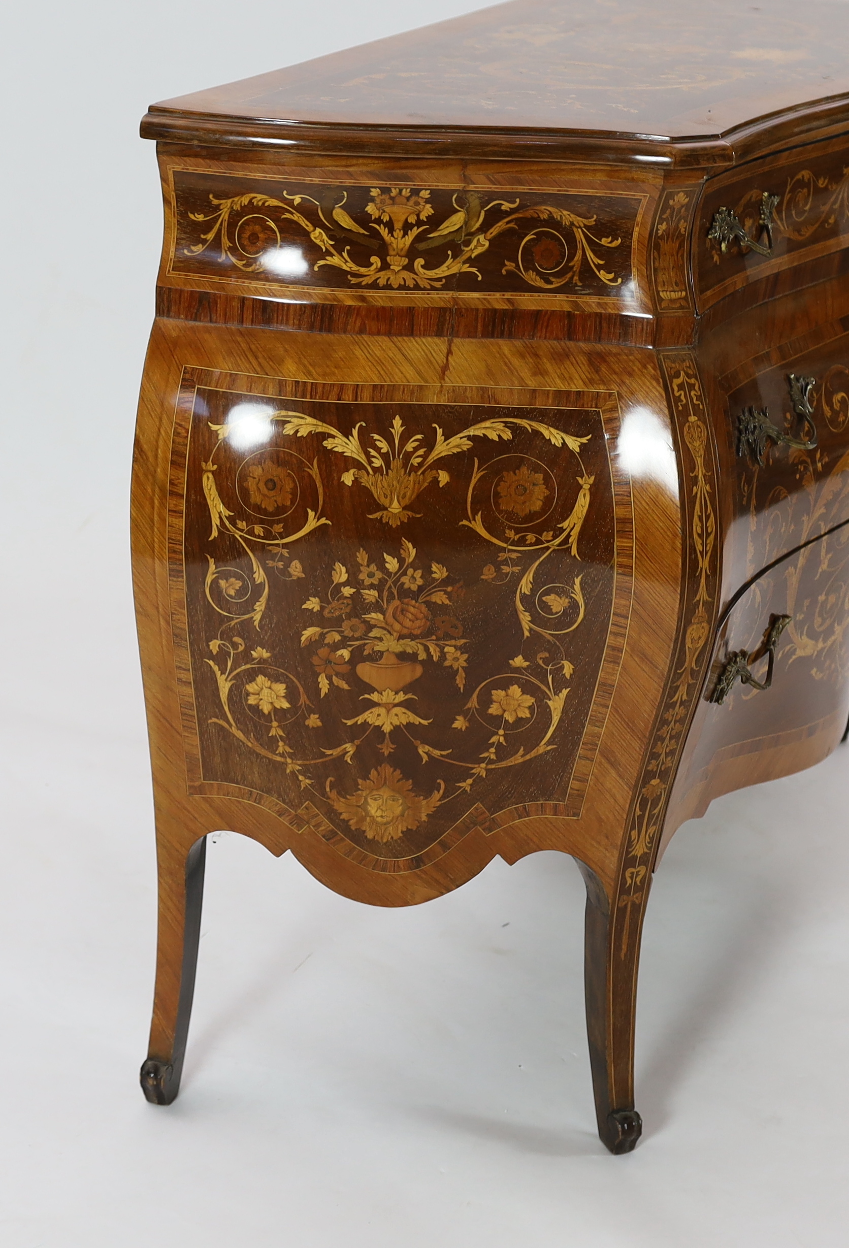 A Continental marquetry inlaid serpentine bombé commode, fitted three long drawers, on scroll - Image 2 of 4