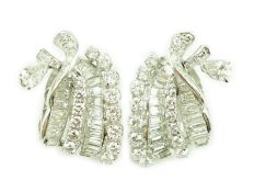 A pair of platinum and round cut, baguette cut and pear cut diamond cluster set scrolling ear clips,