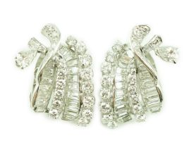 A pair of platinum and round cut, baguette cut and pear cut diamond cluster set scrolling ear clips,