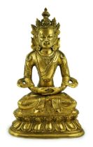 A Tibetan gilt bronze figure of Avalokeshvara, 18th century, seated in padmansana, on a double lotus