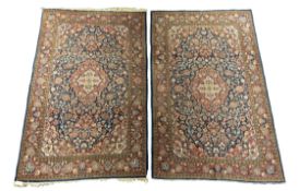 A pair of Kashan blue ground rugs, with central medallion foliate fields and multi-borders, 216 x