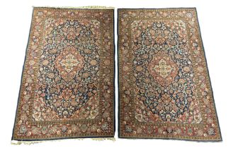 A pair of Kashan blue ground rugs, with central medallion foliate fields and multi-borders, 216 x
