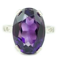 An 18ct white gold and oval cut amethyst set ring, with two stone diamond chip set shoulders, size