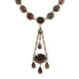 An early 19th century gold, and thirty five graduated foil backed garnet set necklace, with later
