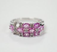 A modern 14k white metal, pink sapphire and diamond cluster set half hoop ring (two sapphires
