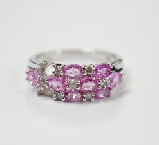 A modern 14k white metal, pink sapphire and diamond cluster set half hoop ring (two sapphires