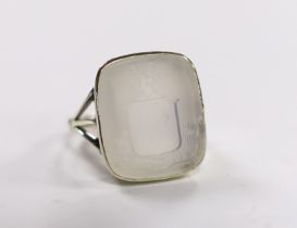 An early 20th century 9ct and white chalcedony set intaglio ring, the matrix carved with family