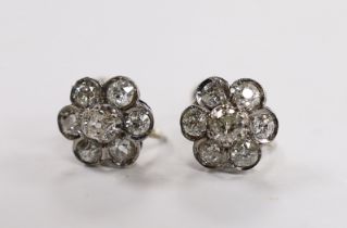 A pair of white metal and seven stone diamond set flower head cluster ear clips, 12mm, gross 4.9