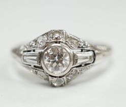 An Art Deco white metal and diamond cluster ring, set with round and trapeze cut stones, size R,