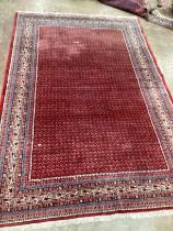 A Sarouk Mir red ground carpet, 288 x 191cm***CONDITION REPORT***PLEASE NOTE:- Prospective buyers