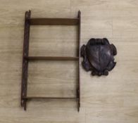 A Chippendale style open hanging shelf and an 18th/19th century carved mahogany armorial shield,