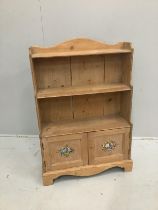 A stripped pine waterfall bookcase with stencilled doors, width 69cm, height 104cm***CONDITION