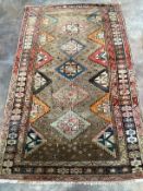 A Caucasian rug with geometric motifs on brown ground, 200 x 122cm***CONDITION REPORT***PLEASE