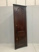 A George III free standing oak corner cupboard, with fielded panelled doors and shelved interior,