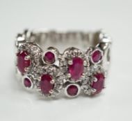 A modern 14ct white gold, ruby and diamond set multi cluster half hoop dress ring, size O, gross
