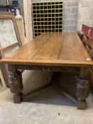 A very large 17th century style oak refectory dining table, with cleated three plank top on carved