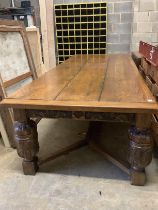 A very large 17th century style oak refectory dining table, with cleated three plank top on carved