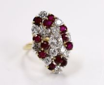A modern yellow metal, ruby and diamond set oval cluster dress ring, size L/M, gross weight 11.4