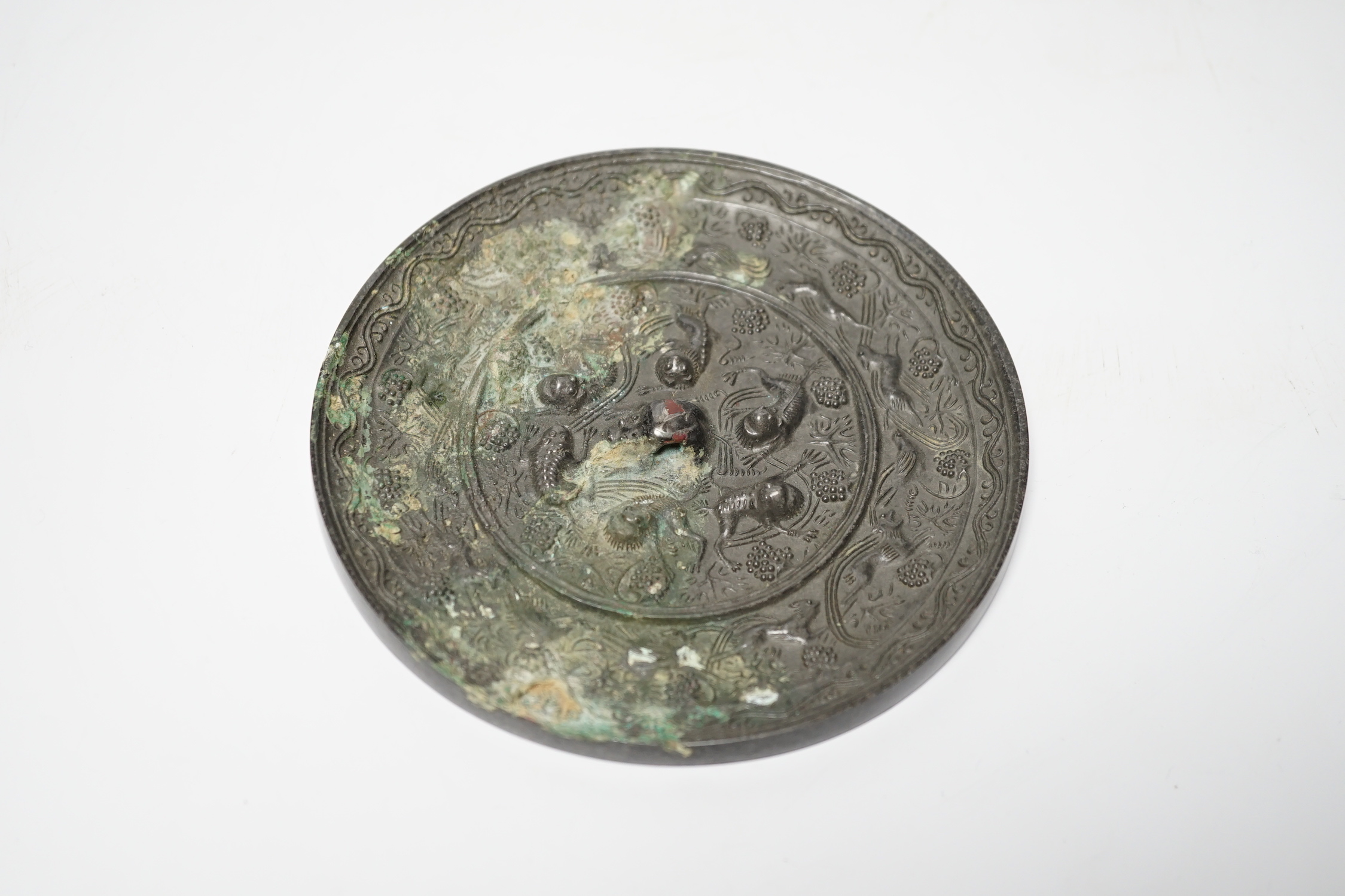 A Chinese cast bronze mirror, decorated with vines, and mythical creatures, diameter 12.5cm - Image 2 of 3