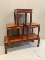 A Chinese hardwood coffee table and a set of three Chinese square topped hardwood tables, largest