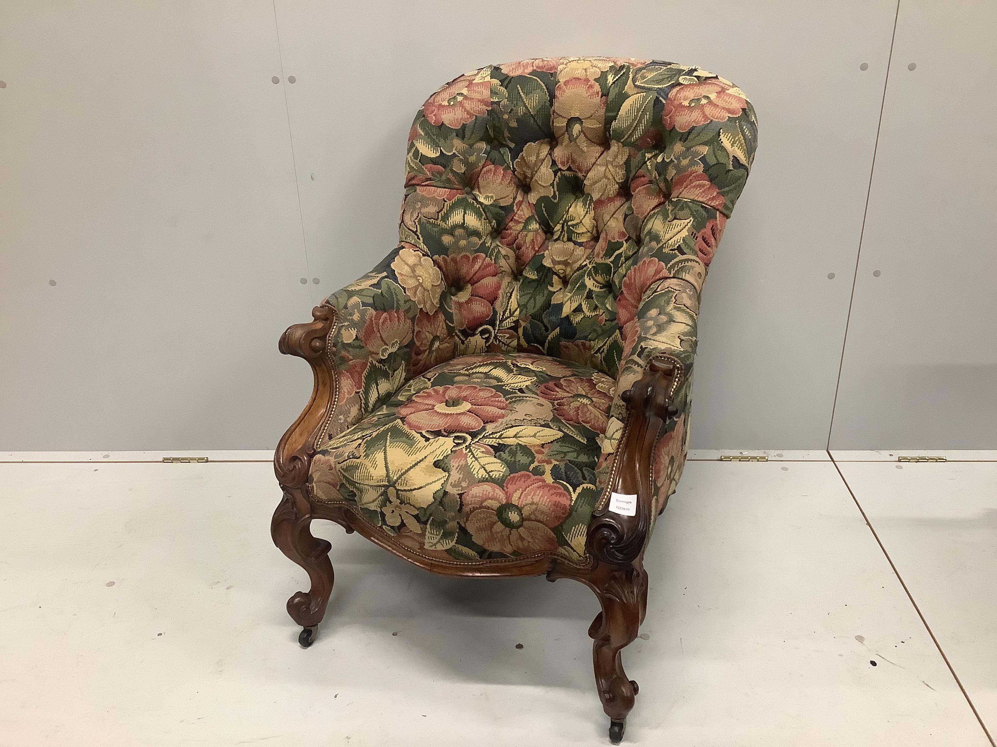 An early Victorian rosewood spoon back armchair with buttoned floral upholstery, width 68cm, depth