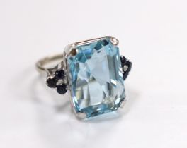 An 18ct white metal and single stone emerald cut aquamarines set dress ring, with six stone sapphire