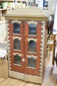 A painted and wallpapered wooden doll's house with front opening double doors, and containing
