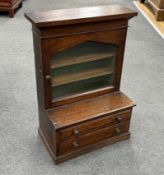 A miniature glazed bookcase with drawers under, height 56cm