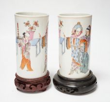 A pair of Chinese cylindrical famille rose brush pots on associated stands, largest 15cm high