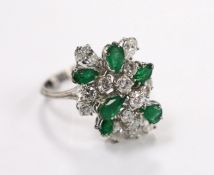 A modern white metal emerald and diamond cluster set dress ring, size R/S, the shank with two sizing