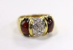 A modern 750 yellow metal and diamond cluster set dress ring, with two stone cabochon garnet set